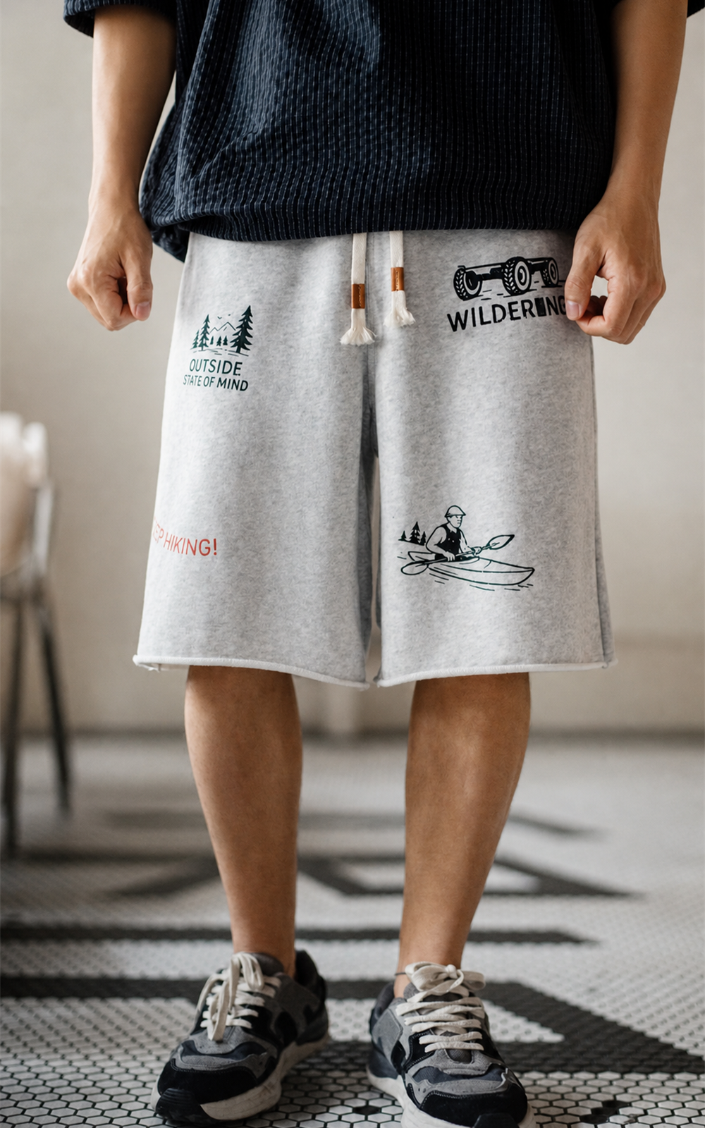 Man in MANLY retro print sweat shorts with navy knit tee — front look