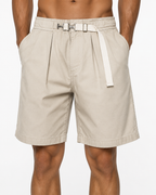 Apricot pleated shorts on model with built-in webbing belt and metal clasp