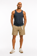 Man in navy tank top wearing khaki pleated shorts with white webbing belt, front view