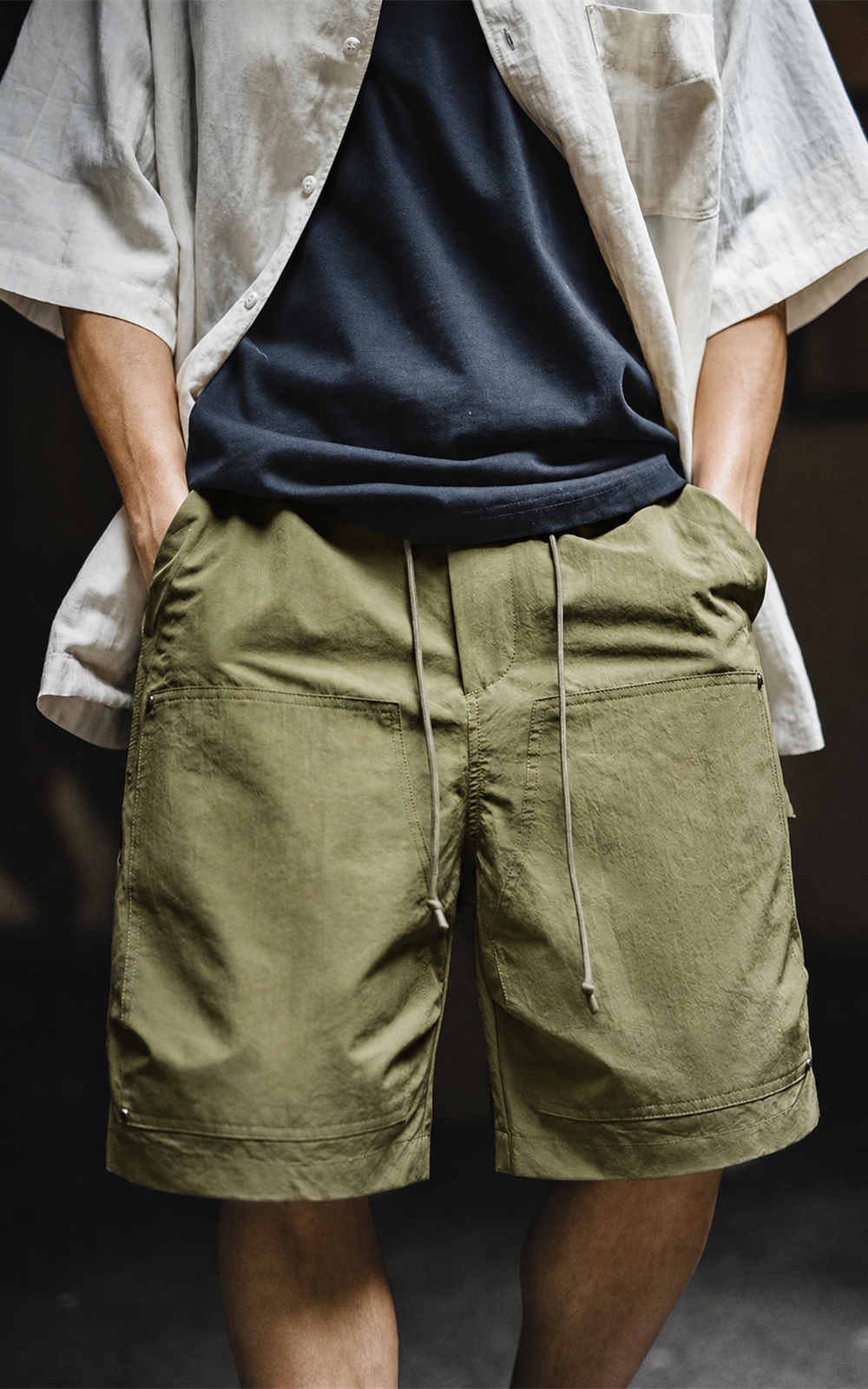 Men's carpenter shorts in olive green — front view with navy tee