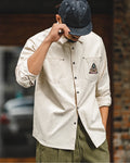 Man wearing the off-white southwestern patch overshirt with olive trousers and denim cap