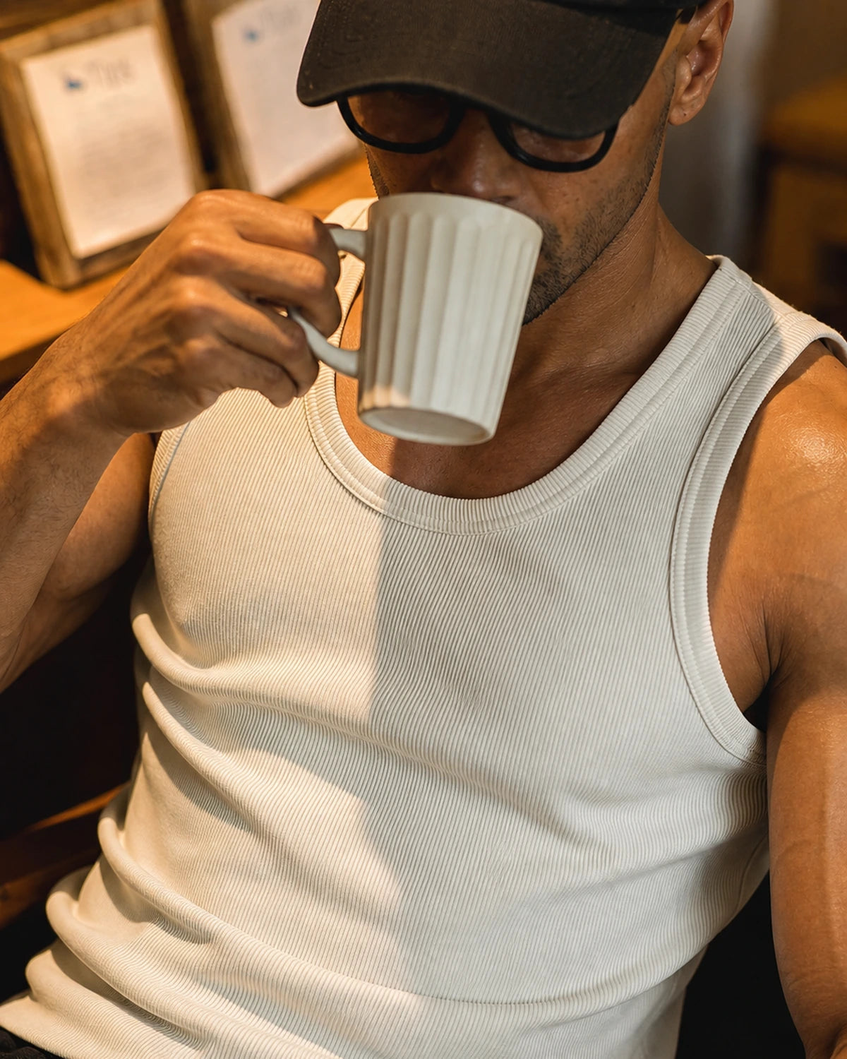 Man drinking coffee in the beige premium ribbed tank