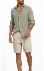 Model in sage green shirt wearing sand khaki pleated shorts