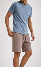 Model in light blue tee walking in taupe knit shorts, studio view