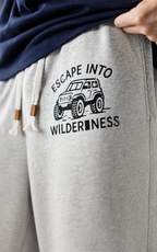 Escape Into Wilderness truck print on grey sweat shorts — close-up