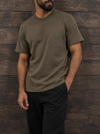 Man in the graphite green pocket tee with black trousers