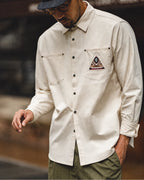 Man in the off-white overshirt showing the woven southwestern pocket patch