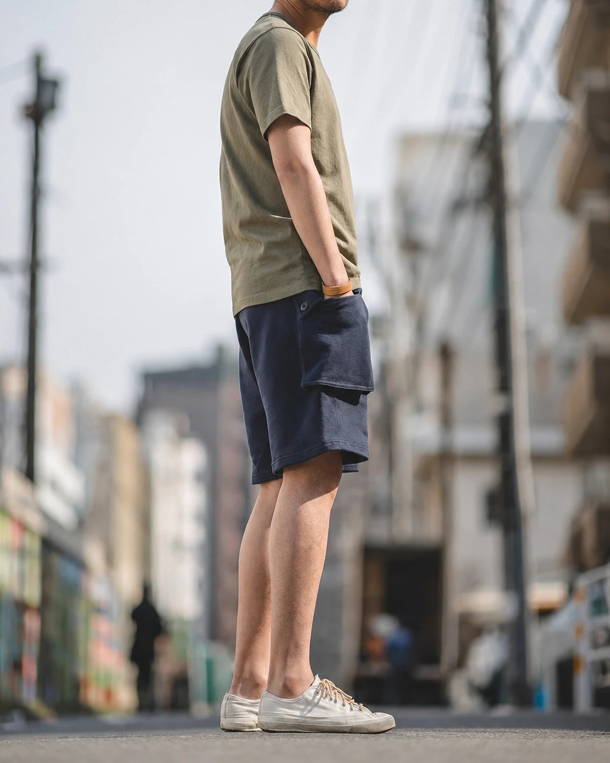Navy knit cargo shorts side profile with white sneakers