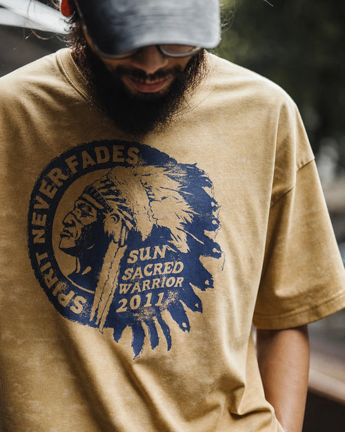Man in the washed mustard amekaji tee and grey cap, front print visible