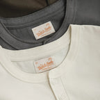 Stacked cold gray and almond white henleys showing placket and label detail