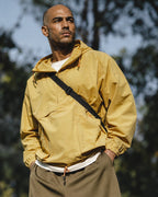 Man in yellow anorak and MANLY army green mesh shorts — outdoor portrait