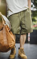 Olive green carpenter shorts with tote bag and work boots