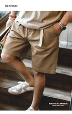 Khaki belted shorts styled with beige T-shirt on wooden stairs