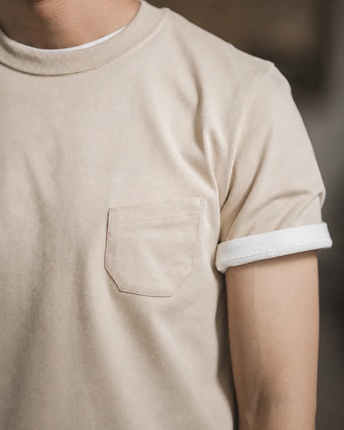 Close-up of the vintage apricot tee's chest pocket and rolled sleeve
