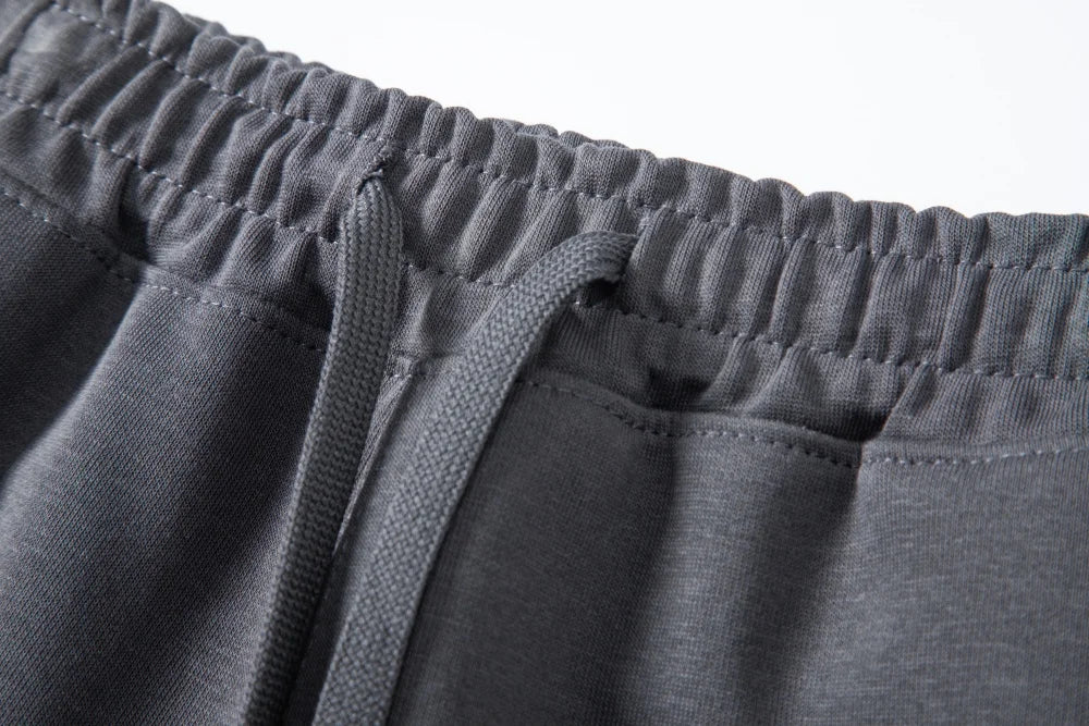 Close-up of dark gray shorts elastic waistband and flat drawcord