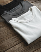 Stacked grey, white and black heavyweight tees showing collar detail