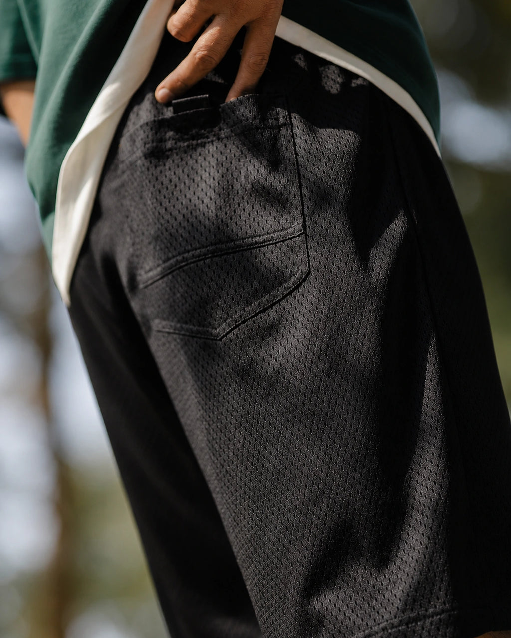 Mesh back patch pocket on black shorts — close-up