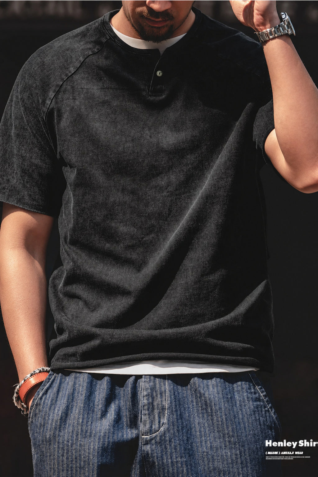 Man in the washed black henley layered over a white tee with denim