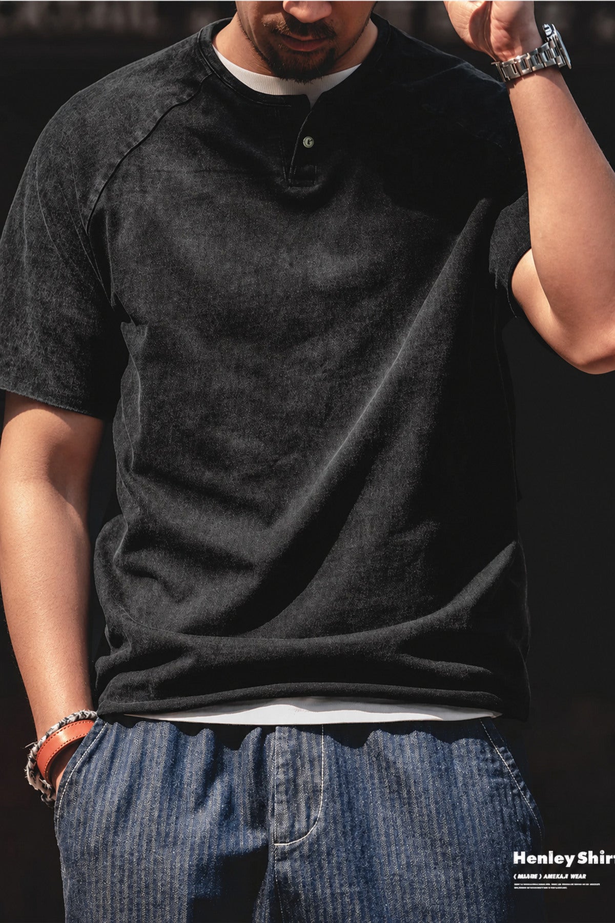 Man in the washed black henley layered over a white tee with denim