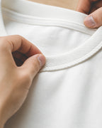 Close-up of the white tee's thick ribbed crew collar