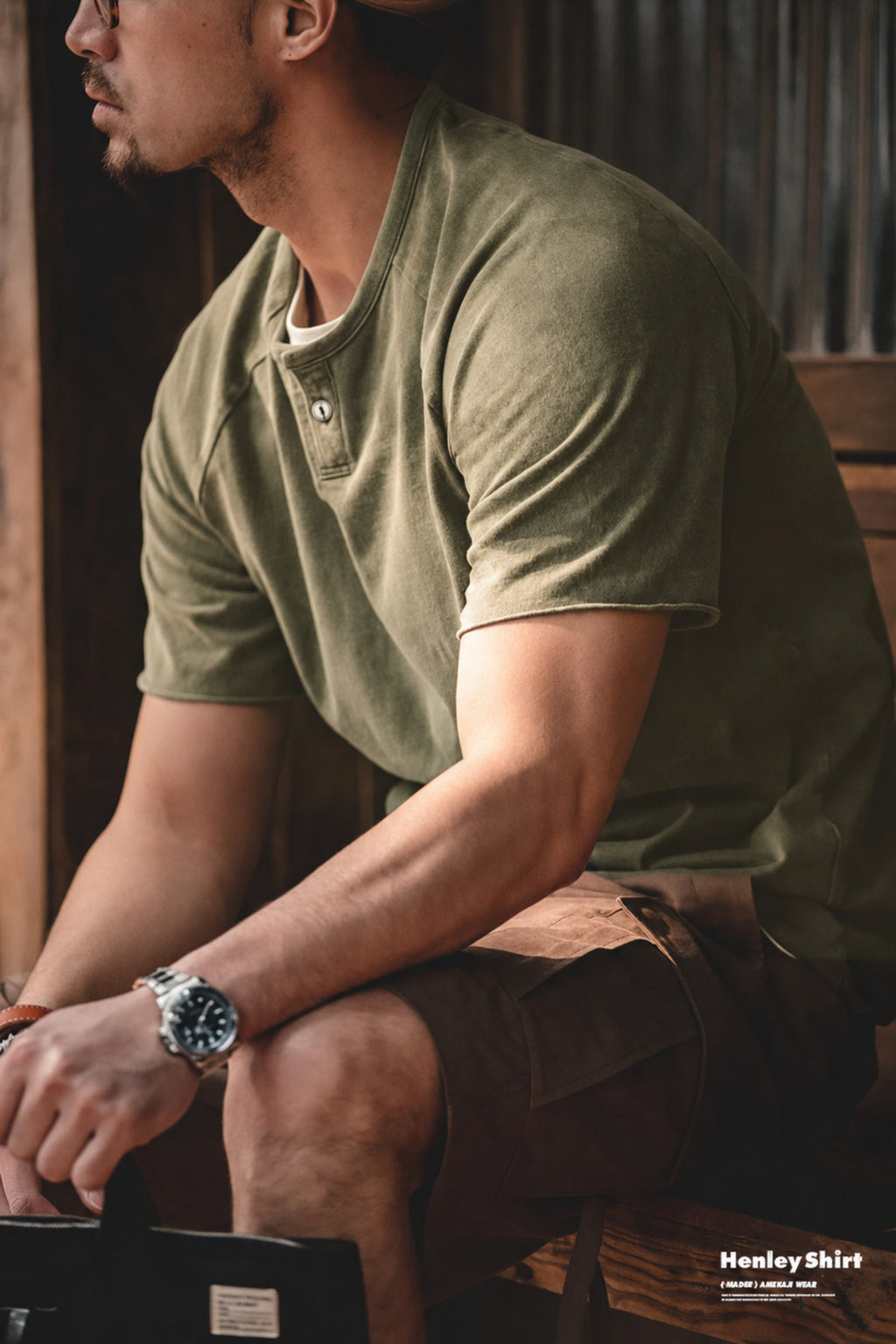 Seated man wearing the washed olive henley