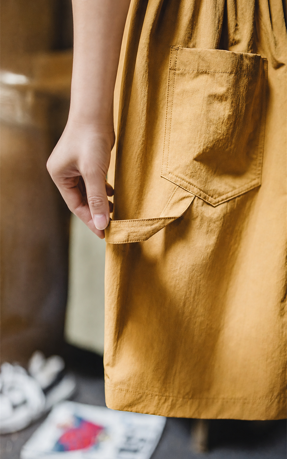 Hand at the hammer loop of canvas yellow carpenter shorts