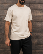 Man wearing the vintage apricot pocket tee with black trousers