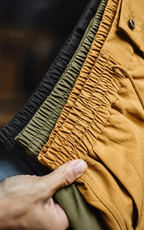 Elastic waistbands of black, olive, and yellow shorts — detail