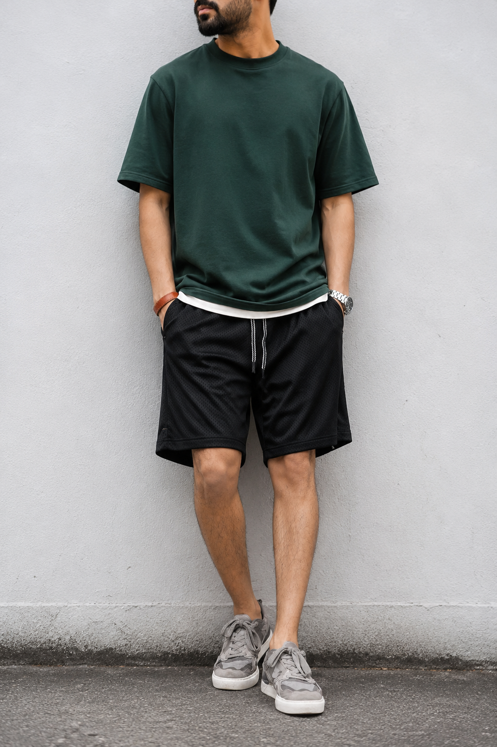 Black mesh shorts with dark green tee and grey sneakers — full look