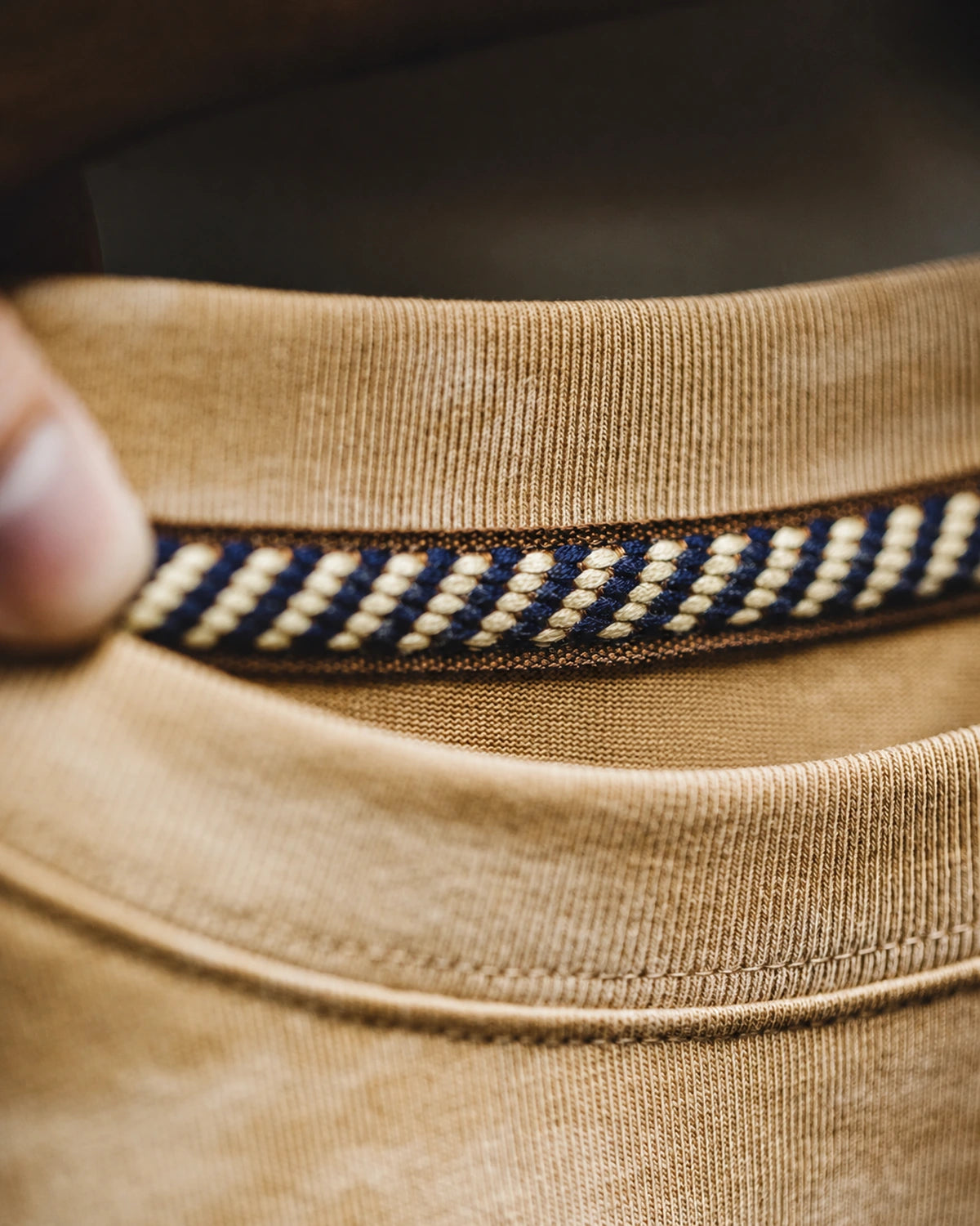 Close-up of the braided contrast neck tape inside the ribbed collar