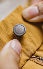 Antique rivet button close-up — canvas yellow shorts