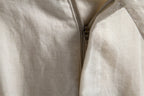 Close-up of metal zip fly on off-white linen blend shorts