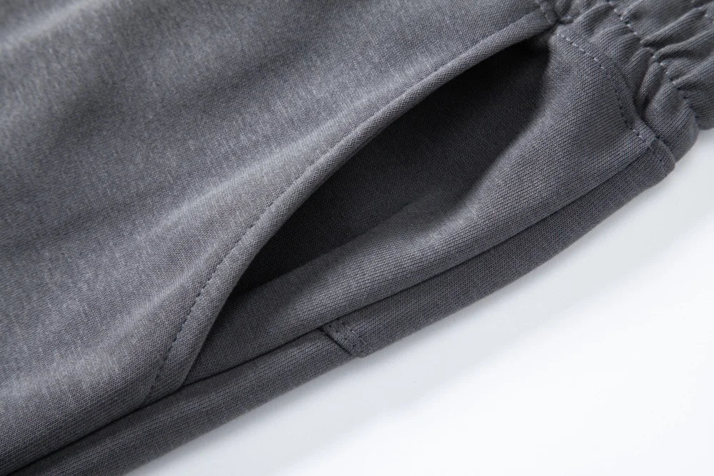 Close-up of slant side pocket on dark gray knit shorts