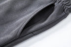 Close-up of slant side pocket on dark gray knit shorts