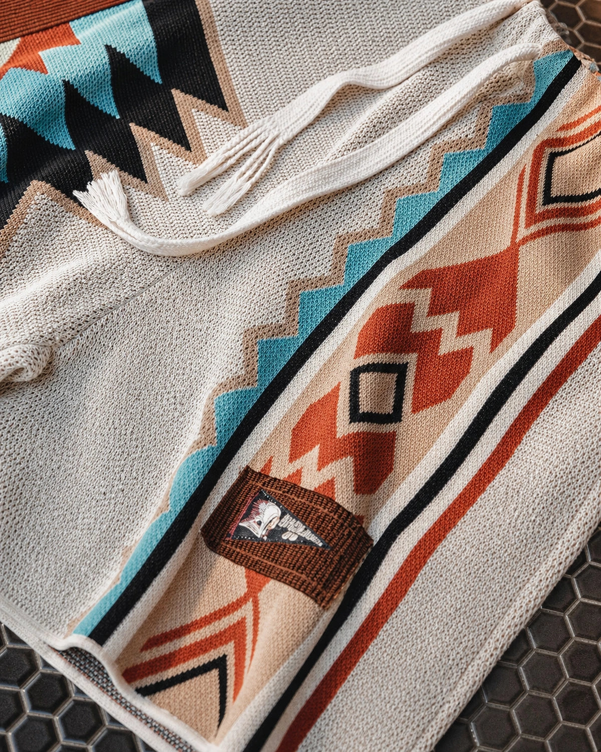 Flat view: woven label patch and curved hem detail