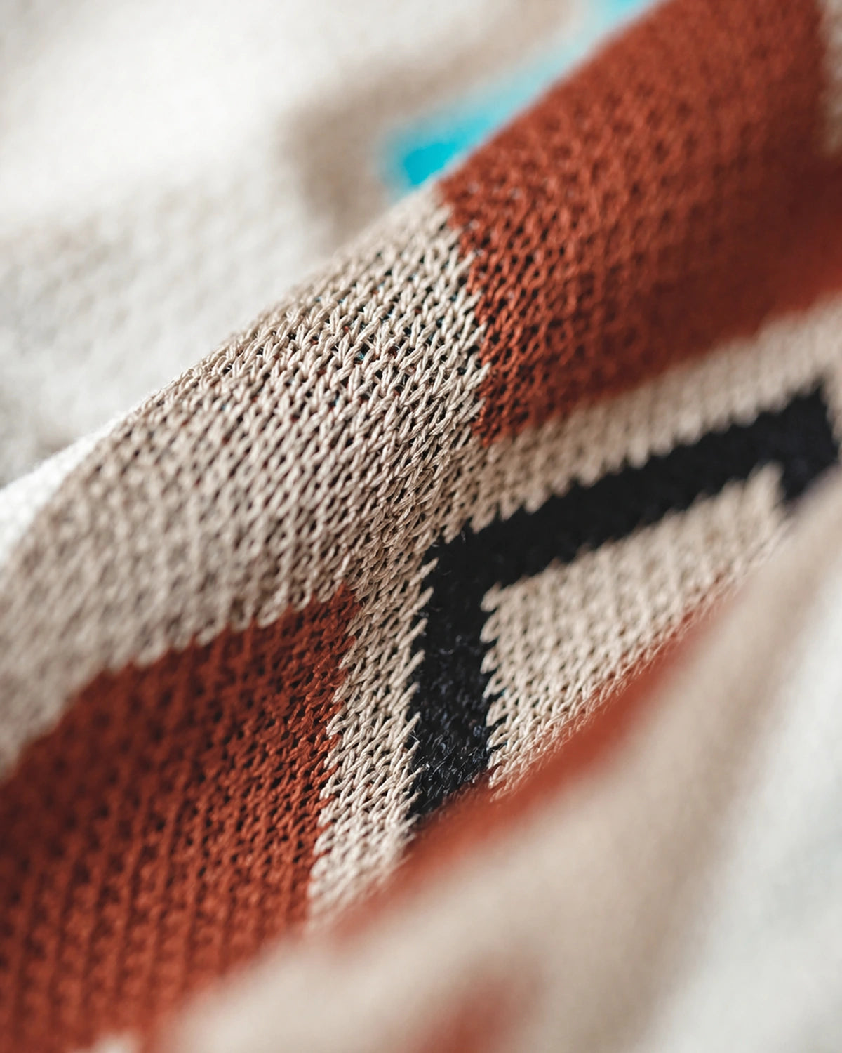 Jacquard knit texture macro — rust, black, tan