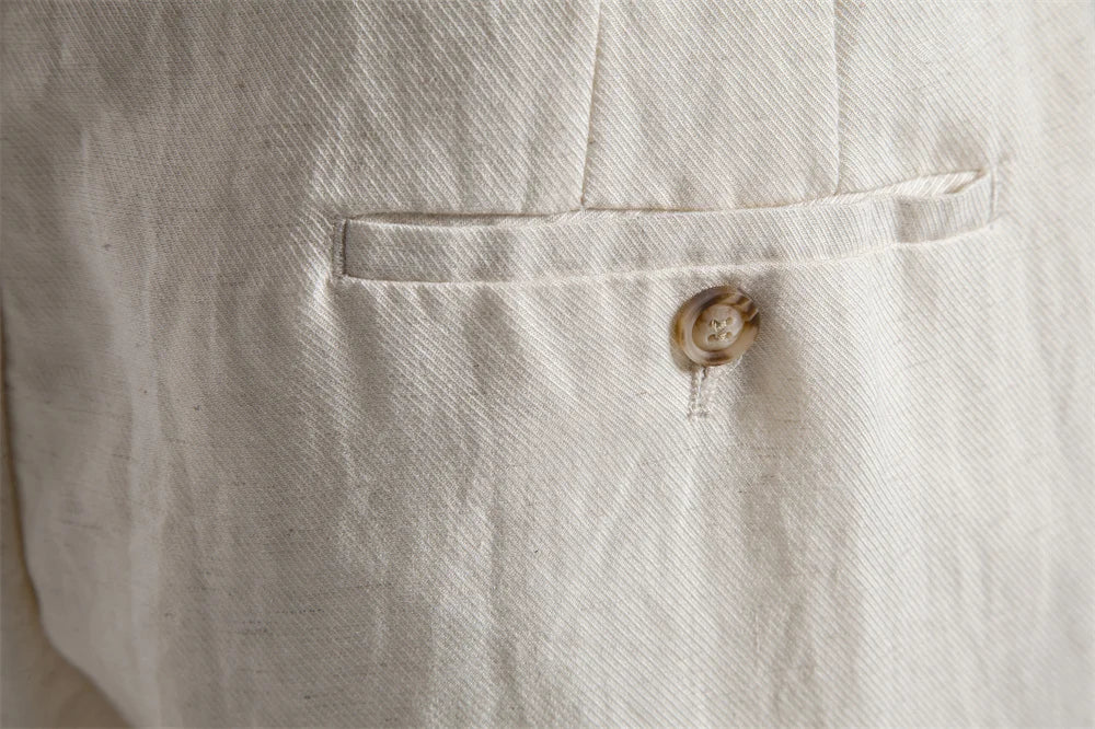 Close-up of buttoned back welt pocket on off-white shorts
