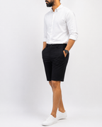 Full-length look: black shorts styled with a white shirt and sneakers