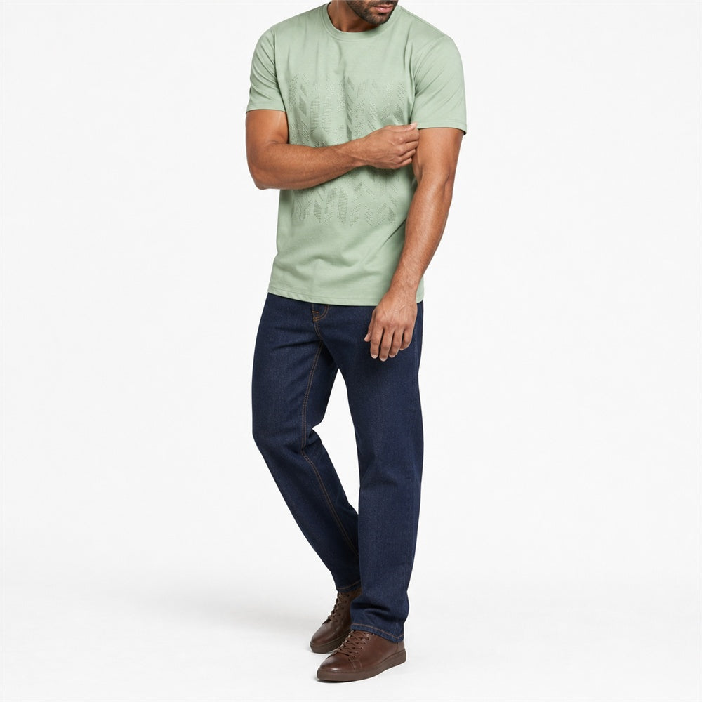 Man wearing the green geometric print t-shirt with dark jeans