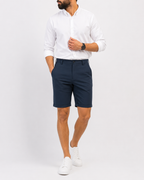 Full-length look: navy shorts with white shirt and sneakers