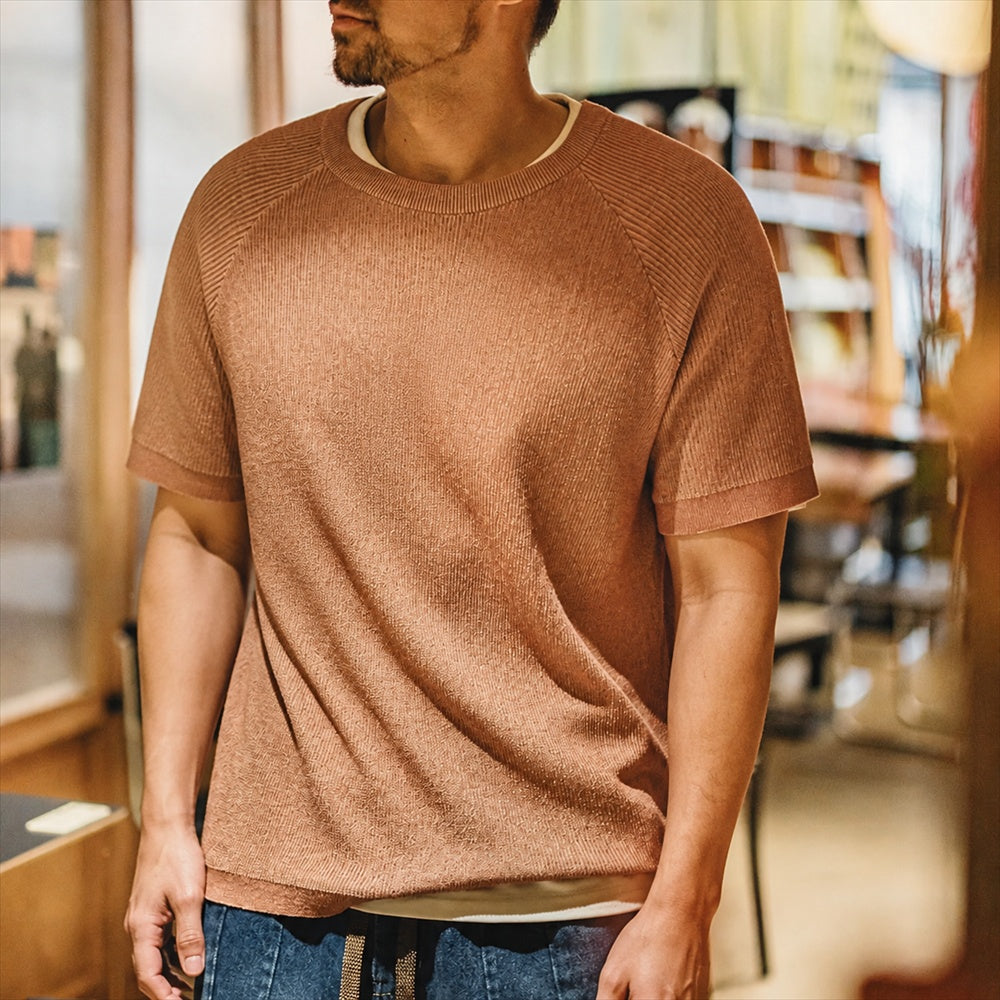 Man in the marled terracotta knitted tee, candid indoor shot