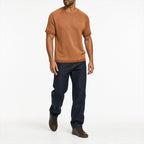 Man wearing the marled terracotta knitted tee with navy trousers, full view