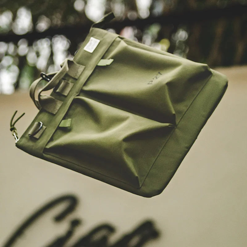 Close view of the Military Green bag's front pockets and strap tab closures