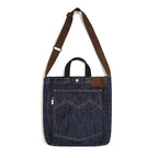 Navy denim tote bag on white showing the strap slider adjuster, top handles and leather corner patch