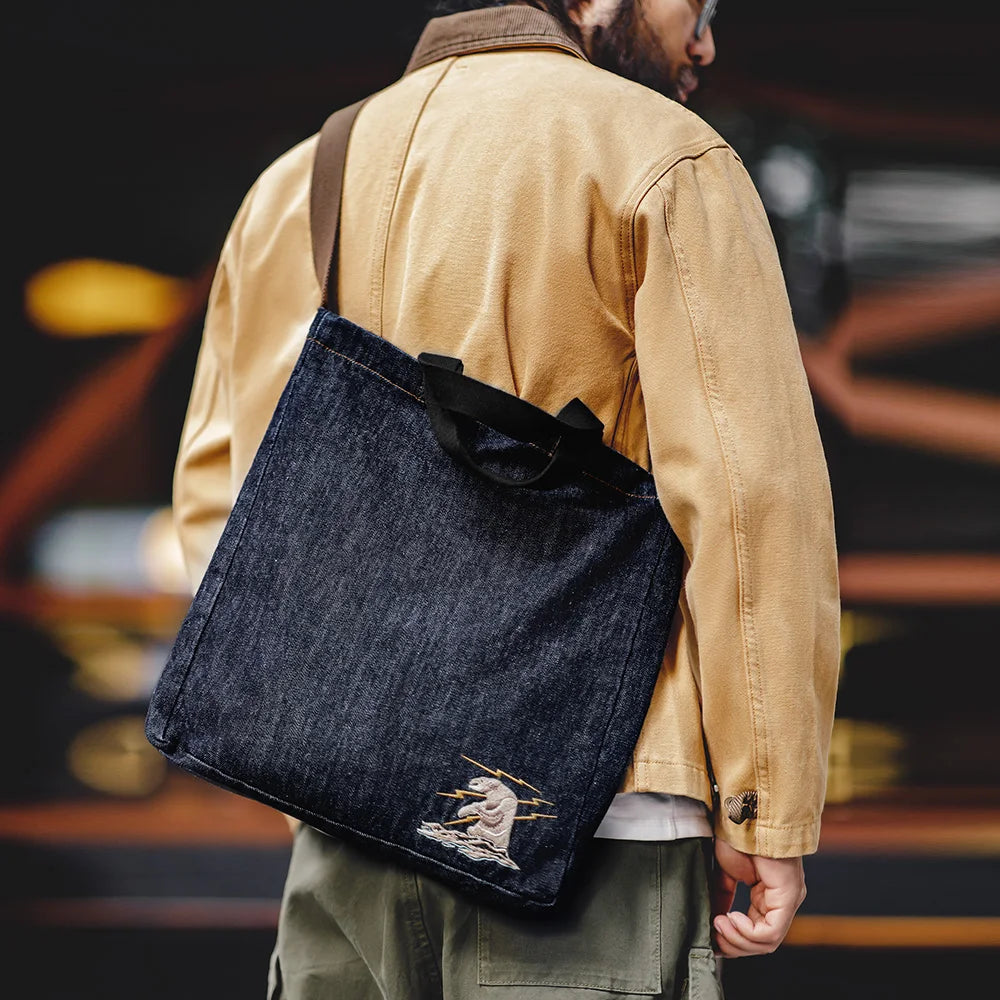 Embroidered panel on the denim tote bag - a cream polar bear surrounded by gold lightning bolts