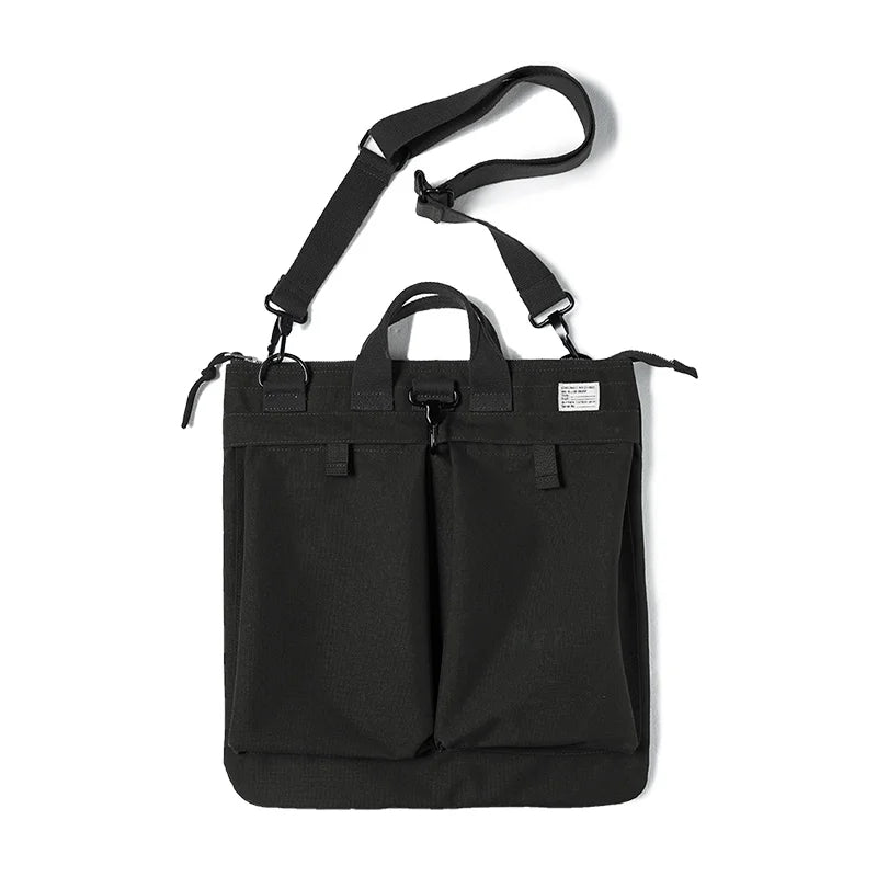 Charcoal helmet messenger bag on white with the detachable shoulder strap and twin top handles