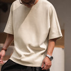 Close-up of the beige boxy tee's thick fabric and wide sleeves