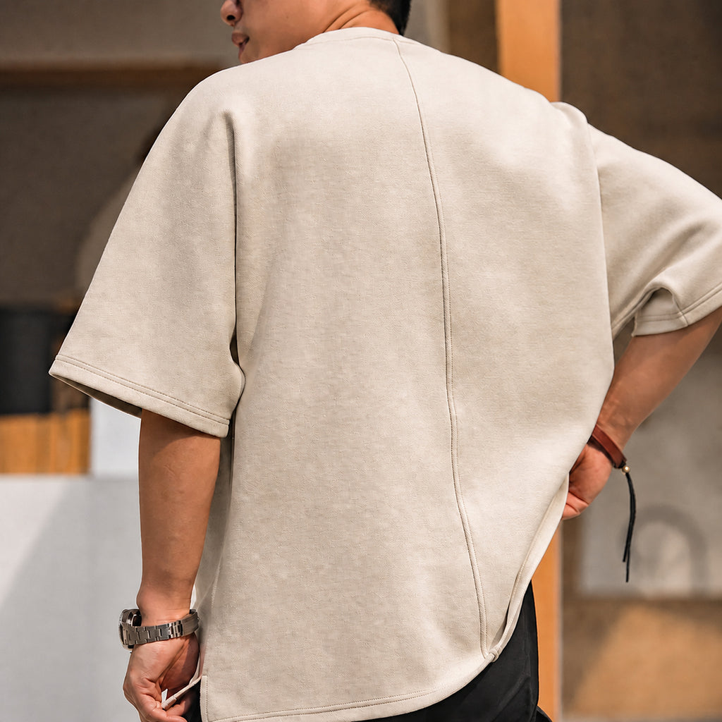 Back view of the beige oversized tee showing the center-back seam