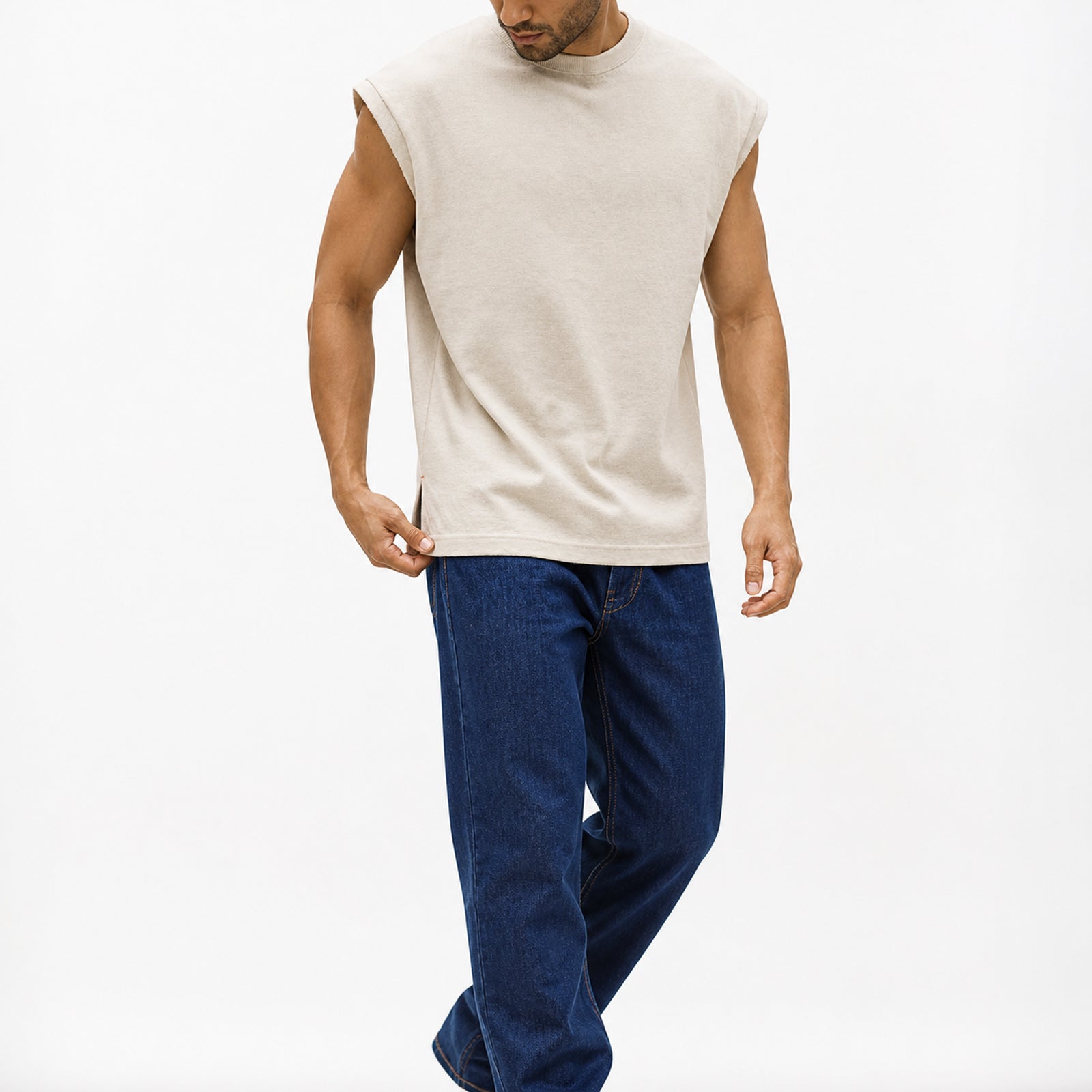 Man wearing the beige knit shoulder vest with navy trousers, full view