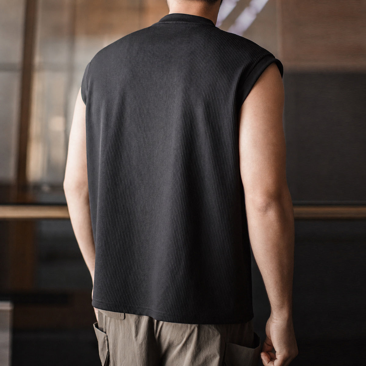 Back view of the black ribbed tank with light trousers